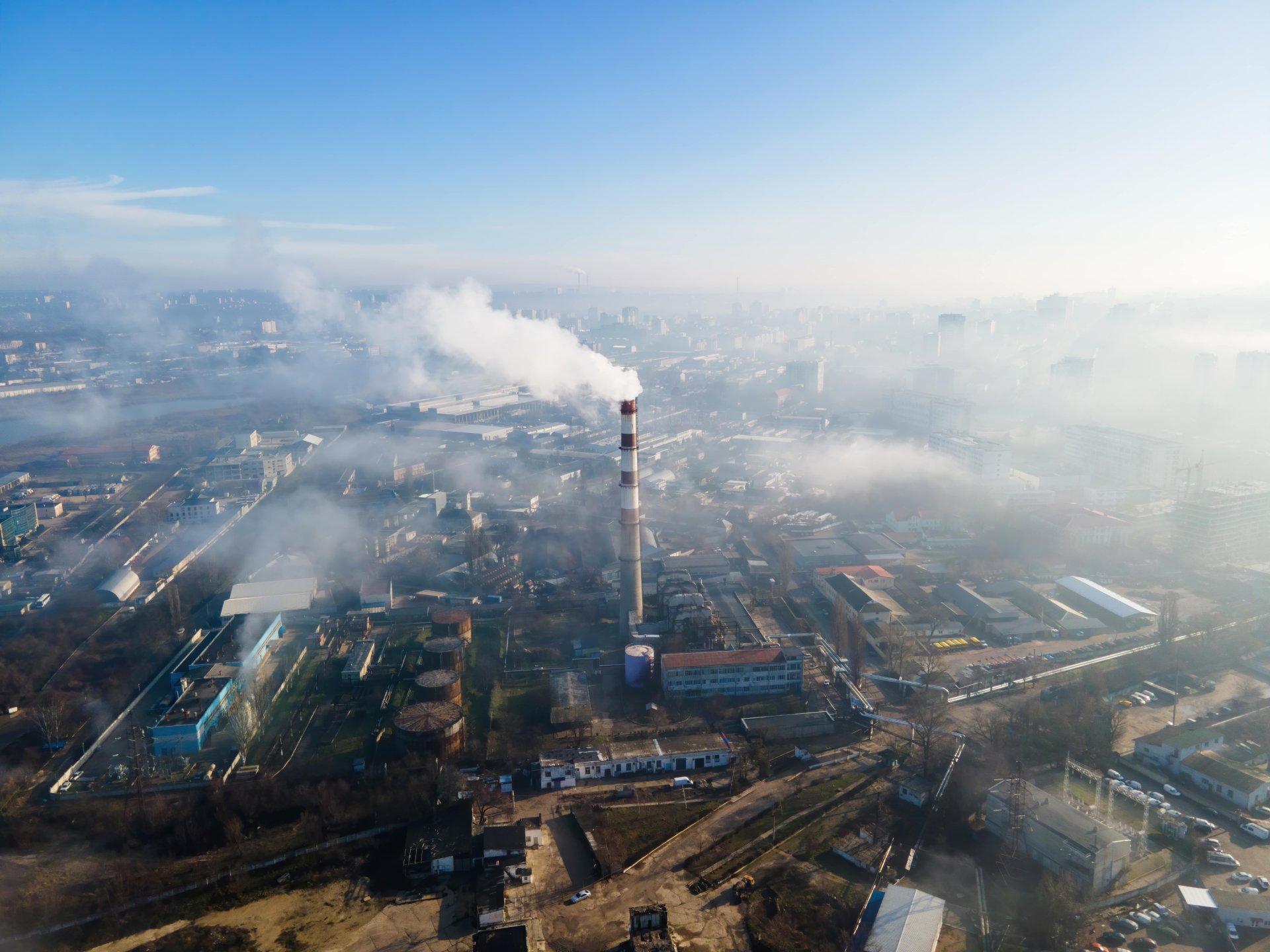 aerial-drone-view-chisinau-thermal-station-with-smoke-coming-out-tube-buildings-roads-fog-air-moldova-min.jpg
